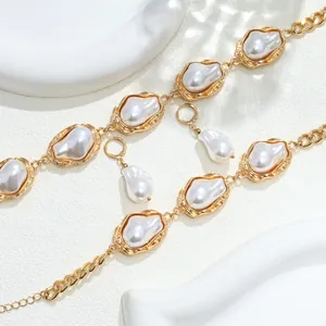 Primo piano di un set elegante di collana e orecchini con perle irregolari dorate.