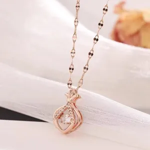 Détail d'un collier pendentif pochette à parfum en or rose avec cristal de pierre dansante