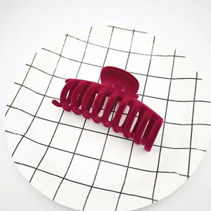 Detalle de una pinza para el pelo de terciopelo burdeos sobre plato de rejilla