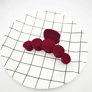 Primer plano de una pinza para el pelo de terciopelo burdeos sobre un plato de rejilla