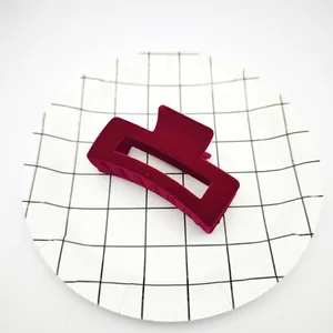 Primer plano de una pinza para el pelo de terciopelo granate en un plato con cuadrícula