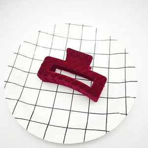 Vista detallada de la textura de terciopelo granate en una pinza para el cabello.