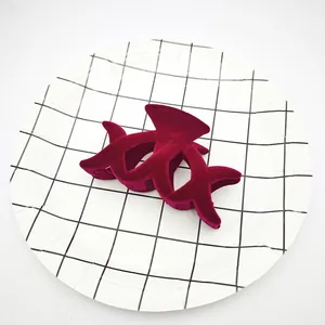 Primer plano de una pinza de pelo flocada rojo vino con textura aterciopelada