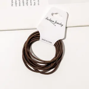 Minimalist set of durable brown high-elastic hair ties on white display packaging card
