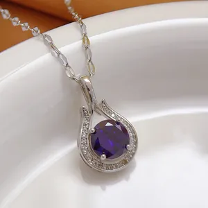 Detailed macro shot of a silver-toned necklace pendant featuring a large purple gemstone