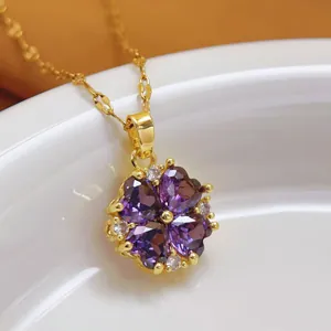 Close-up of elegant flower pendant necklace with purple heart stones in gold plating