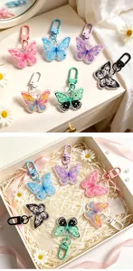Vibrant acrylic butterfly keychains presented in a gift box with shredded paper.