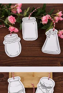 Close-up of blank white jar-shaped cardstock tags with red and white hanging twine
