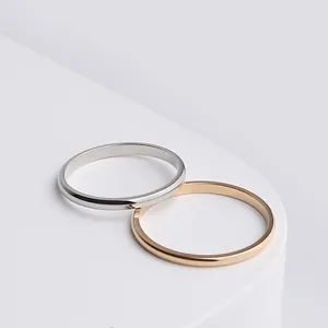 Close-up detail of two minimalist titanium steel slim bands in silver and rose gold finishes