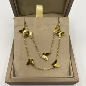 Gros plan d'un bracelet de cheville papillon en acier titane doré dans une boîte cadeau