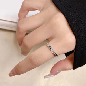 Close-up of titanium steel ring with "CLOSE MY EYES I FEEL YOU" engraving on finger.