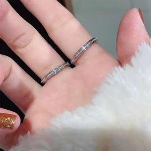 Close-up detail of minimalist silver titanium steel rings with romantic engraved text.