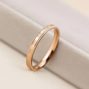 Close-up detail of a rose gold titanium steel ring with elegant engraved English letters