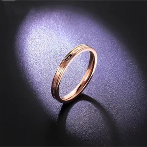 Detailed close-up of a stylish rose gold titanium steel ring with romantic English engraving