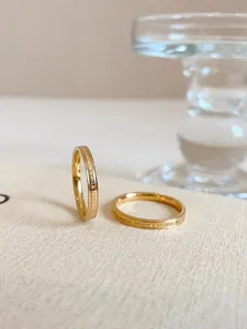 Close-up detail of a simple gold stainless steel ring with elegant English letter engraving