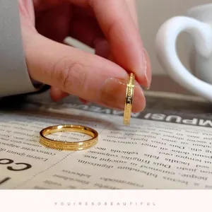 Detailed view of minimalist gold titanium steel ring with English letter engraving
