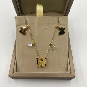 Détail d'un bracelet de cheville papillon doré avec cristaux dans un écrin beige