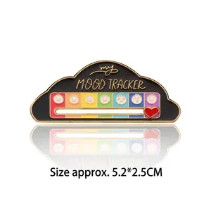 Detalle del pin esmaltado Mood Tracker con corazón deslizante sobre escala emoji