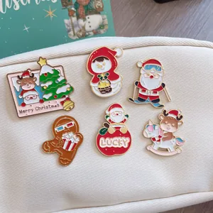 Close-up of cute Christmas enamel pins featuring Santa, reindeer, and gingerbread man.