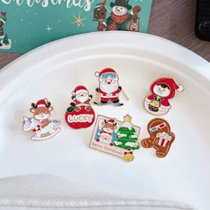 Detailed view of cute Christmas enamel pins featuring Santa, reindeer, and gingerbread man
