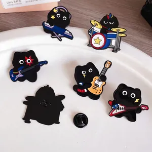 Detail showing a collection of cute black cat music band enamel pins on a white plate.