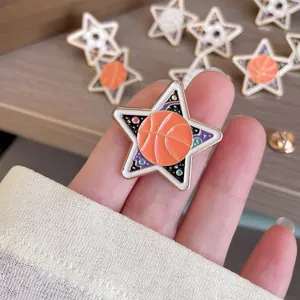 Close-up detail of a star-shaped basketball enamel pin with vibrant orange finish