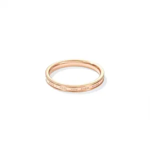 Minimalist rose gold titanium steel ring with engraved English text on white background