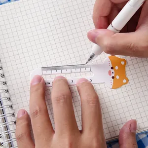 Cute cartoon Shiba Inu animal ruler bookmark placed on a grid notebook with a white pen