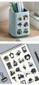 Schwarze Rosensticker im Gothic-Stil auf einem Notizbuch und Stifthalter dekoriert