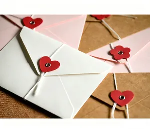 Primer plano detallado de un sobre de papel blanco con cierre de cordón en forma de corazón.