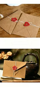 Detalle de sobre de papel kraft con botón de flor roja y cierre de cordón sobre madera
