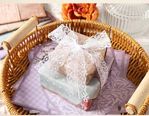Detalle de papel decorativo vintage elegante para regalo con un lazo de encaje blanco