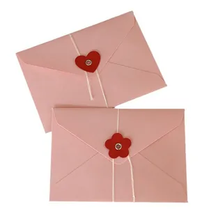 Sobres de cartulina rosa con cierres de cordel de corazón y flor para tarjetas regalo