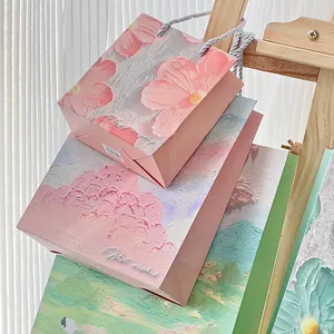 Detailed view of pink oil painting gift bags with artistic flower patterns.