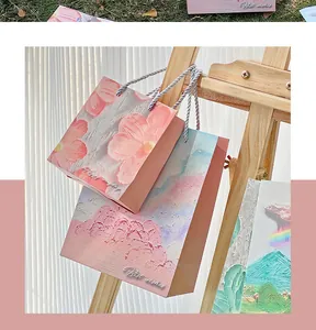 Artistic oil painting gift bags hanging on a wooden easel with textured floral designs