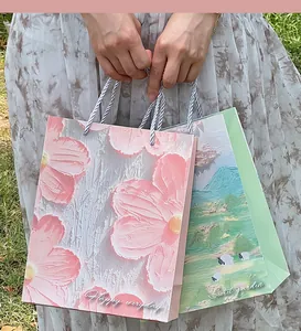 Artistic oil painting style gift bags with floral and landscape patterns in hands
