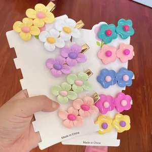 Close-up of colorful flower hair clips in various candy tones on white display cards