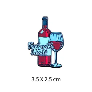 Détail d'une broche émaillée avec bouteille et verre de vin, taille 3,5 x 2,5 cm.