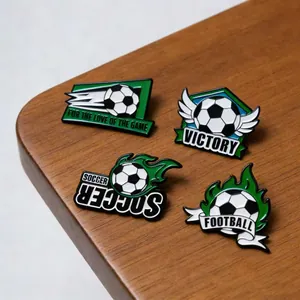 Primo piano dettagliato di vivaci spille in smalto a tema calcio su superficie in legno.