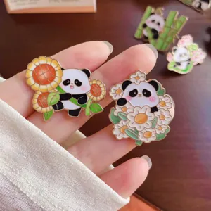 Close-up detail of cute cartoon panda enamel pins featuring sunflower and daisy flower designs