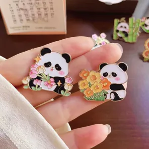 Detailed close-up of cute cartoon panda enamel pins featuring sunflowers and tulips
