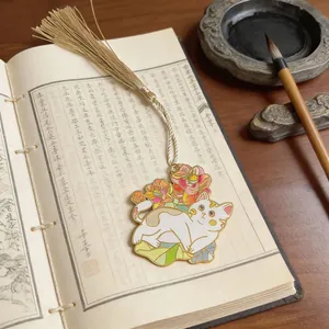 Detailed view of an elegant cat metal bookmark with a silk tassel on vintage book