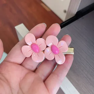 Close-up of pink flower hair clips with sweet candy-colored petals and golden base