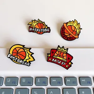 Detail view of four basketball themed enamel pins featuring MVP and flame motifs