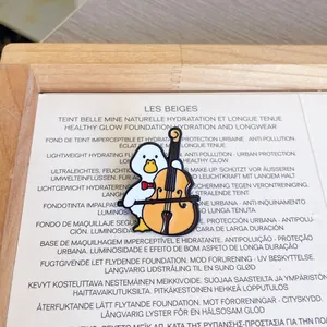 Close-up detail of a cute cartoon duck enamel pin playing a cello on a stylish background