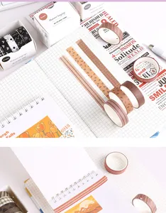 Detailopname van washi tape rollen met herfstthema en decoratieve strips op ruitjespapier