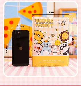 Schattig geel cartoon notitieboek dagboek met afmetingen 15x20cm naast een mobiele telefoon