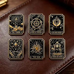 Detailed view of six gold and black enamel tarot card theme brooches on leather