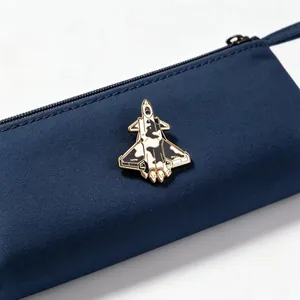 Detailed macro view of fighter jet enamel pin on navy blue fabric pouch