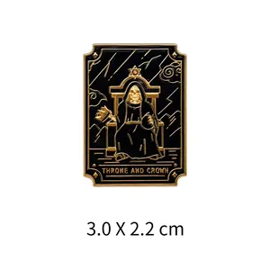 Close-up of a black and gold Tarot-themed metal pin featuring a skeleton on a throne